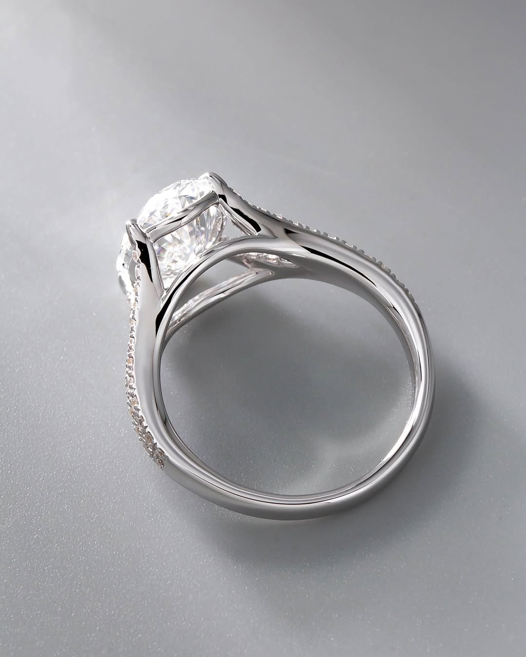 Side profile view of a 3 CT oval cut lab grown diamond engagement ring with split-shank pavé band in white gold.