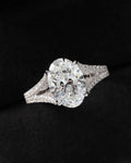 Direct top view of a 3 carat oval lab diamond showcasing brilliant facets and split pavé diamond shoulders.