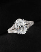 Direct top view of a 3 carat oval lab diamond showcasing brilliant facets and split pavé diamond shoulders.