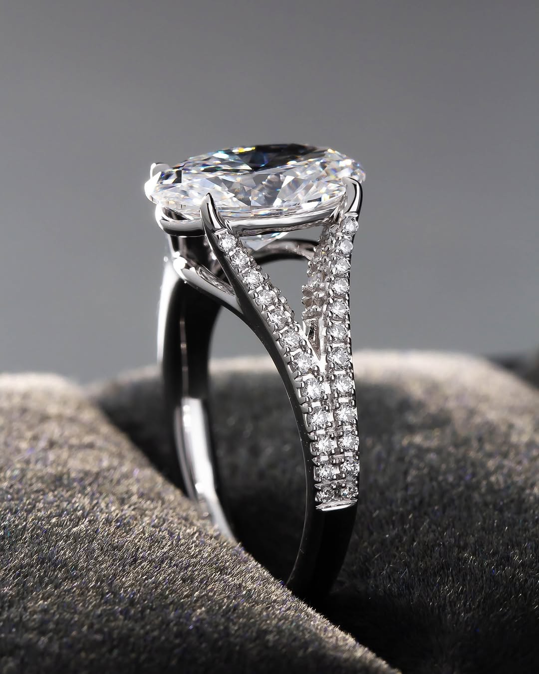 Close-up profile showing the double row micro-pavé split-shank design supporting an oval diamond center.