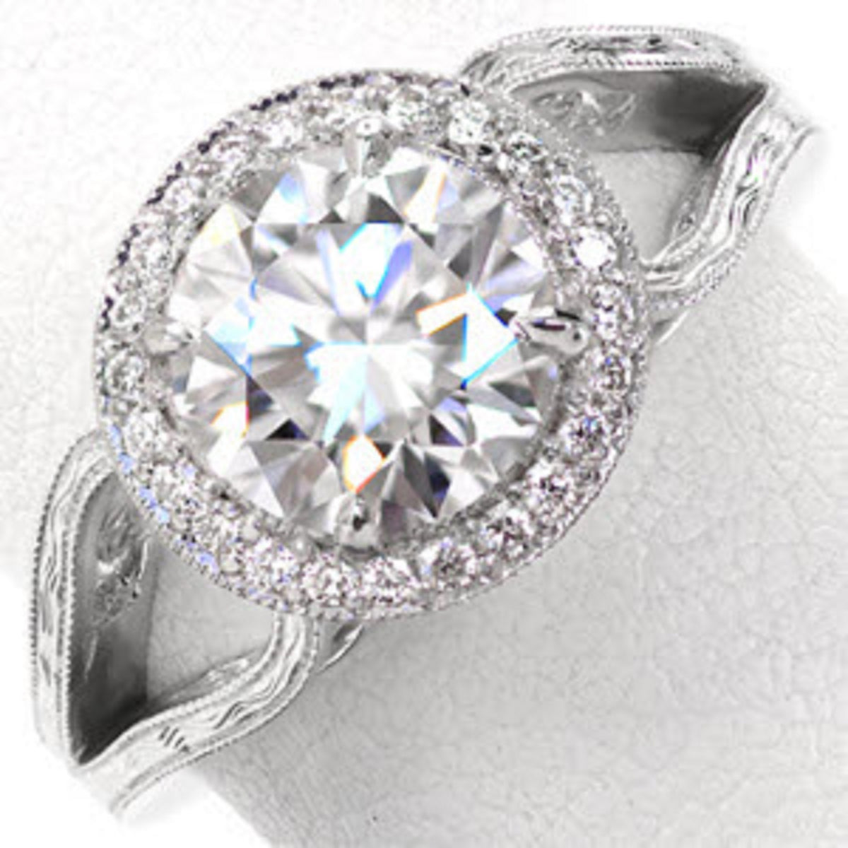 Top-down view showcasing a 3 carat round cut lab diamond with a sparkling milgrain halo and hand-engraved white gold band.