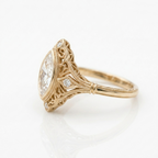 Side profile of 3 carat marquise cut lab-grown diamond engagement ring highlighting yellow gold milgrain and filigree work.