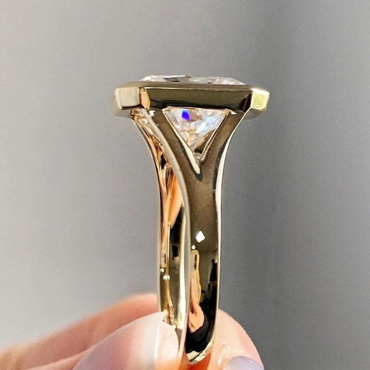 Side profile view of a 4 CT radiant cut lab grown diamond ring in a yellow gold bezel setting.
