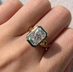 On-finger view of a 4 carat radiant cut lab grown diamond bezel set engagement ring in yellow gold.