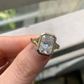 Front close-up view of radiant cut lab diamond framed by a smooth yellow gold bezel border.