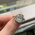 Front close-up view of radiant cut lab diamond framed by a smooth yellow gold bezel border.