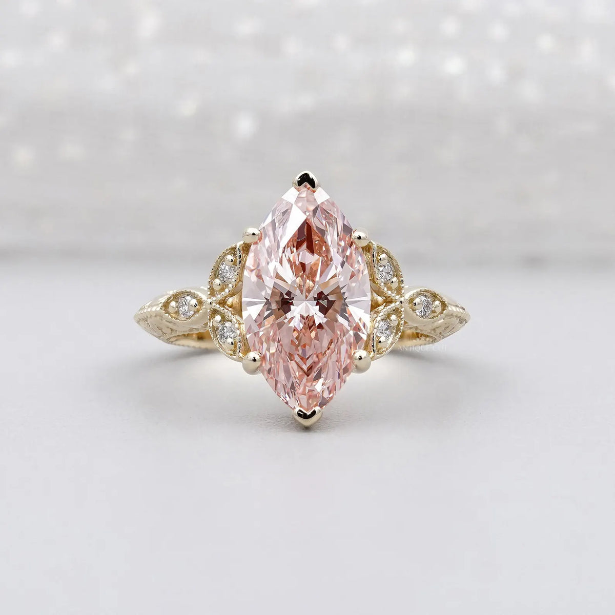Front view of a 3 carat fancy pink marquise lab grown diamond in a yellow gold vintage floral setting.