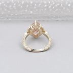 Bottom view displaying the open undergallery basket and detailed carved band of a pink marquise diamond ring.