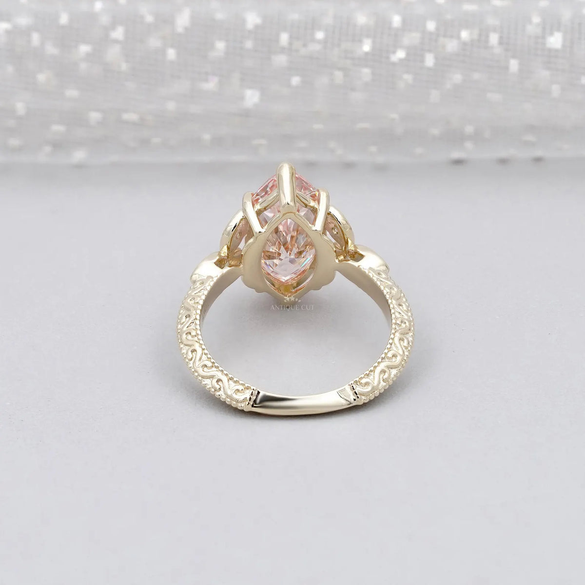 Bottom view displaying the open undergallery basket and detailed carved band of a pink marquise diamond ring.