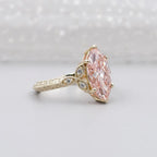Angled view highlighting the leaf-inspired side accent pods and milgrain detailing on a pink marquise engagement ring.