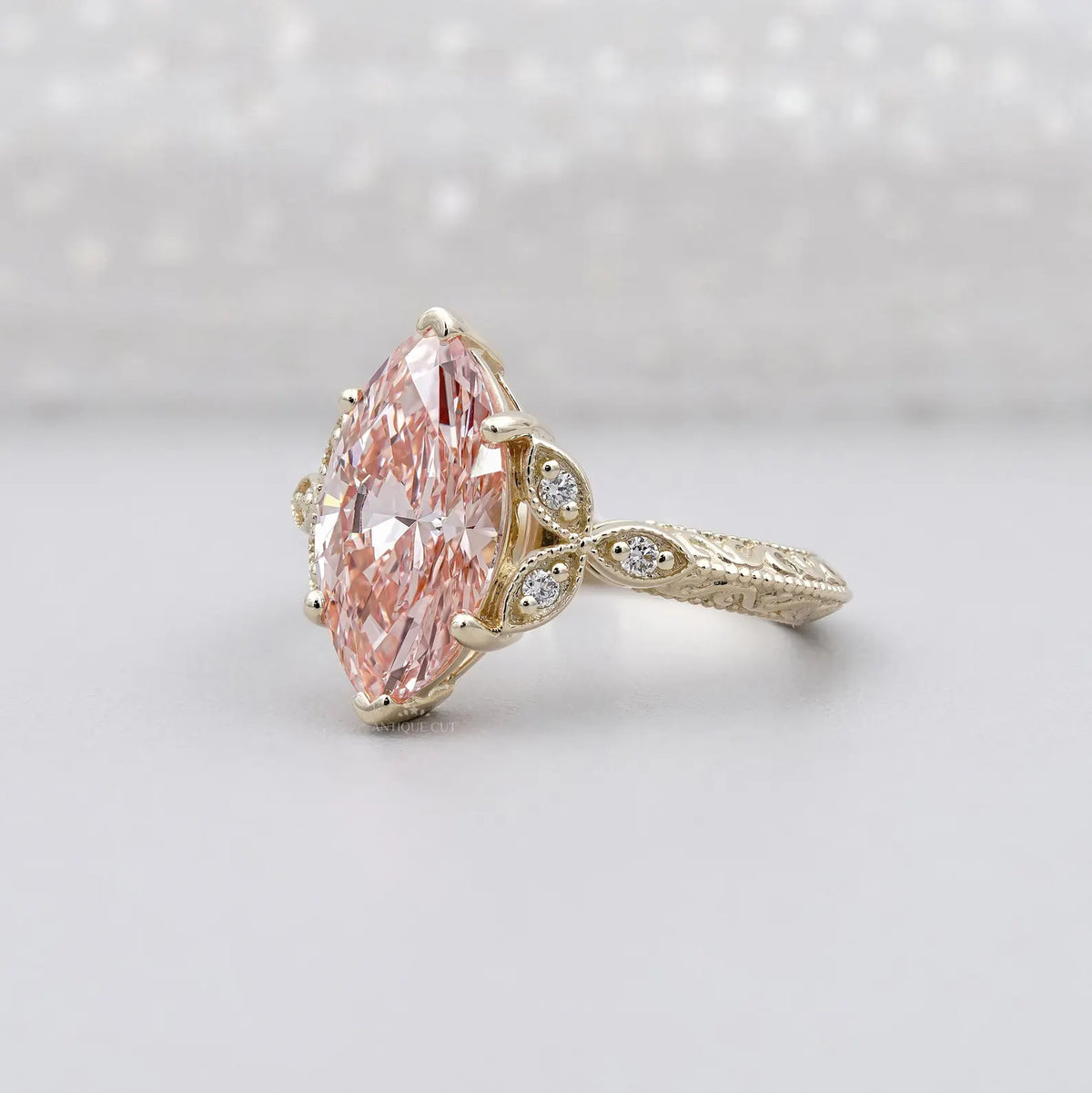 Perspective shot showing the brilliant faceting of the 3 CT blush pink marquise lab diamond in yellow gold.