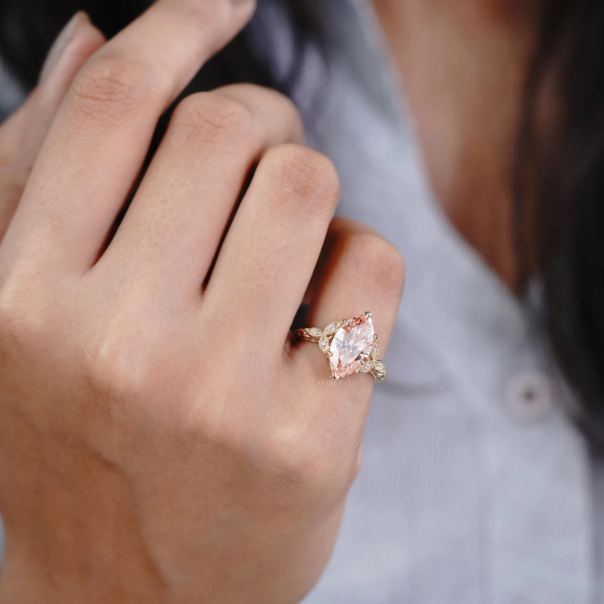 On-hand view of a woman wearing a 3 CT fancy pink marquise cut lab grown diamond vintage engagement ring.