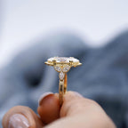 Profile view held between fingers showing leaf cluster accents and hand-engraved scrollwork shank.