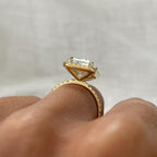 Elevated side profile view of a 4 carat emerald cut halo engagement ring in solid yellow gold.