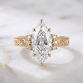 Front product photo of 4 CT marquise lab created diamond engagement ring with side clusters isolated on marble background.