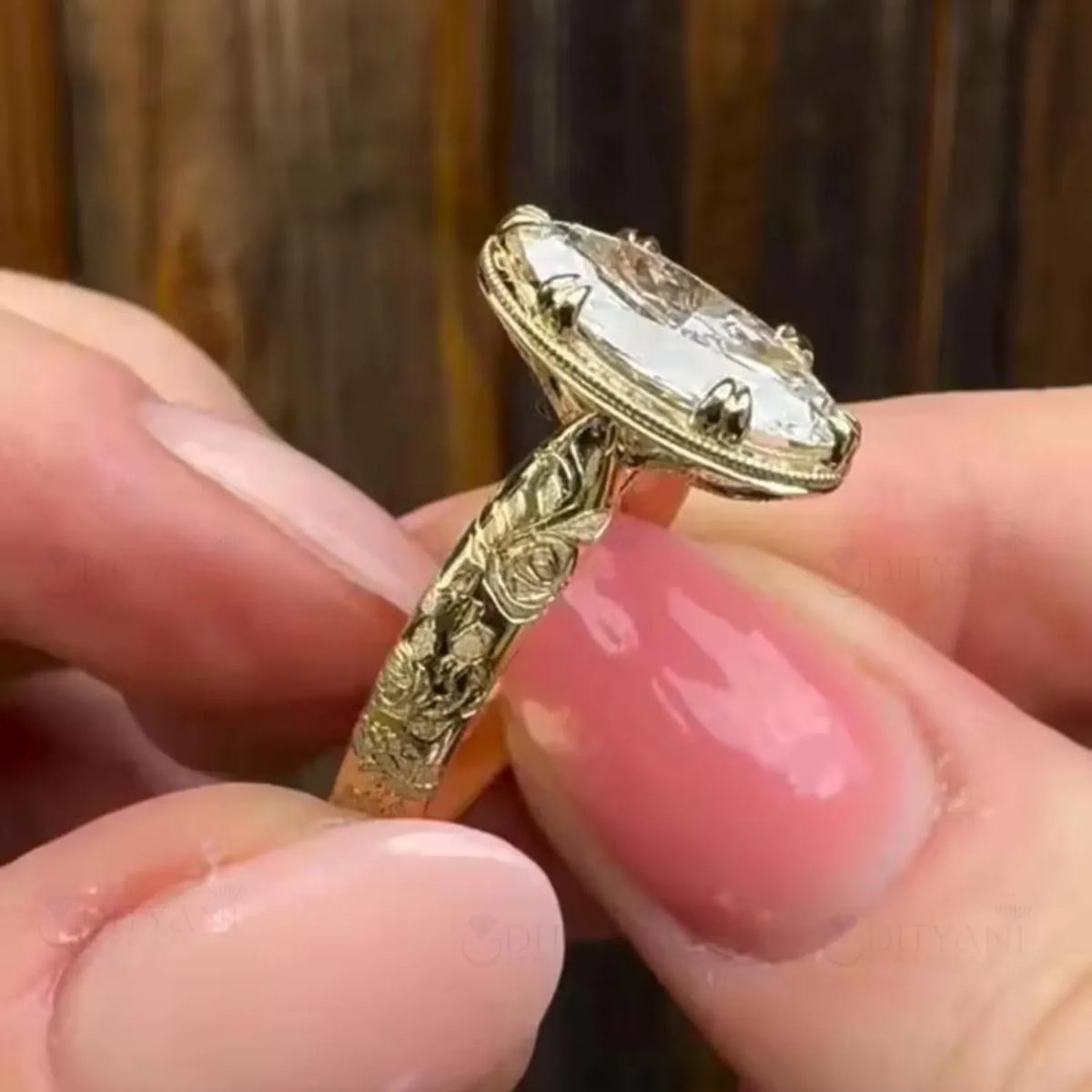 Detailed view of hand-carved rose floral motifs on a yellow gold oval lab diamond engagement ring band.