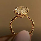 Side profile showing under-gallery basket and twisted cable band on a 3 carat oval lab diamond ring.