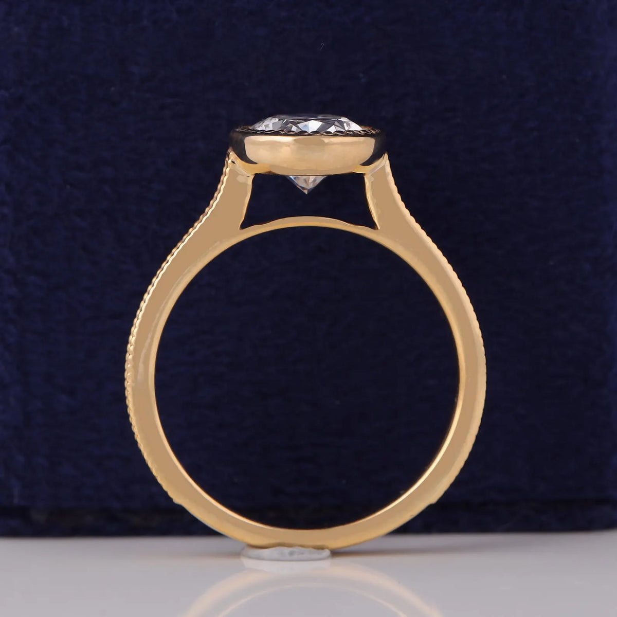 Side profile view of a 3 CT oval lab grown diamond ring in cathedral yellow gold bezel setting.