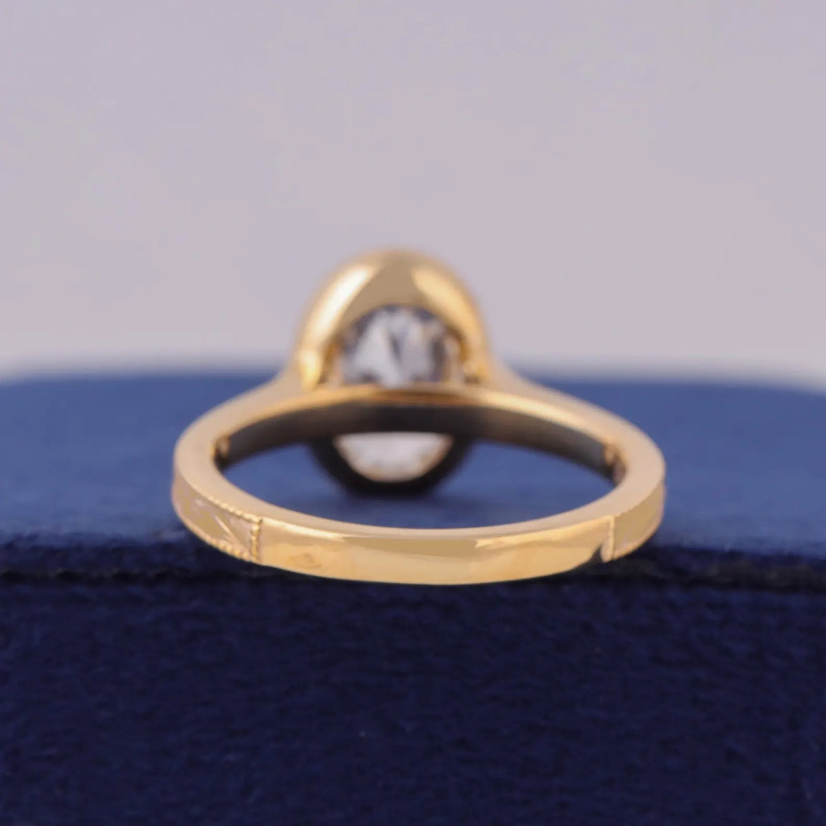 Bottom view of yellow gold ring shank showing bezel setting structural support.