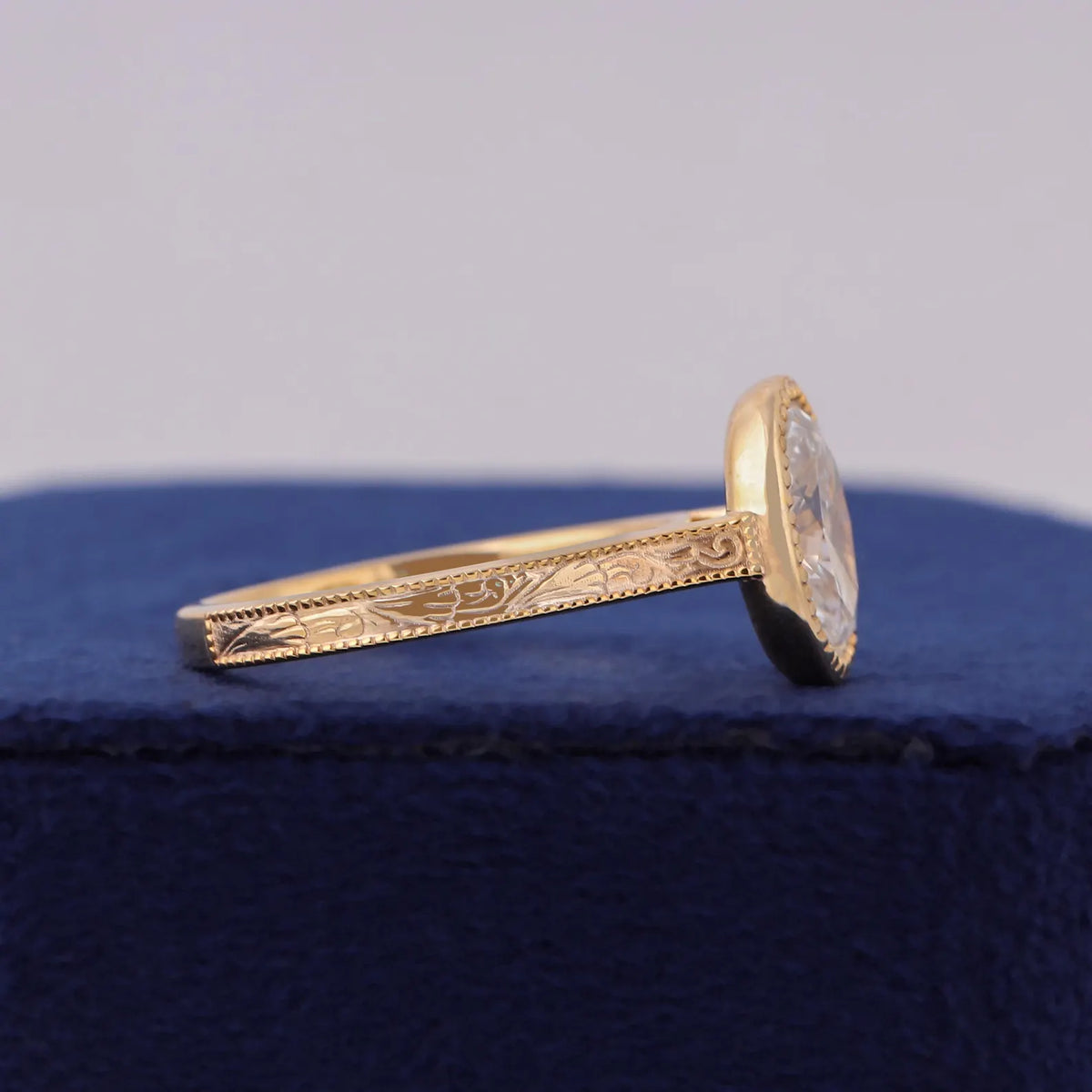 Angled studio view of 3 CT oval lab grown diamond ring showing hand-engraved shank detail.