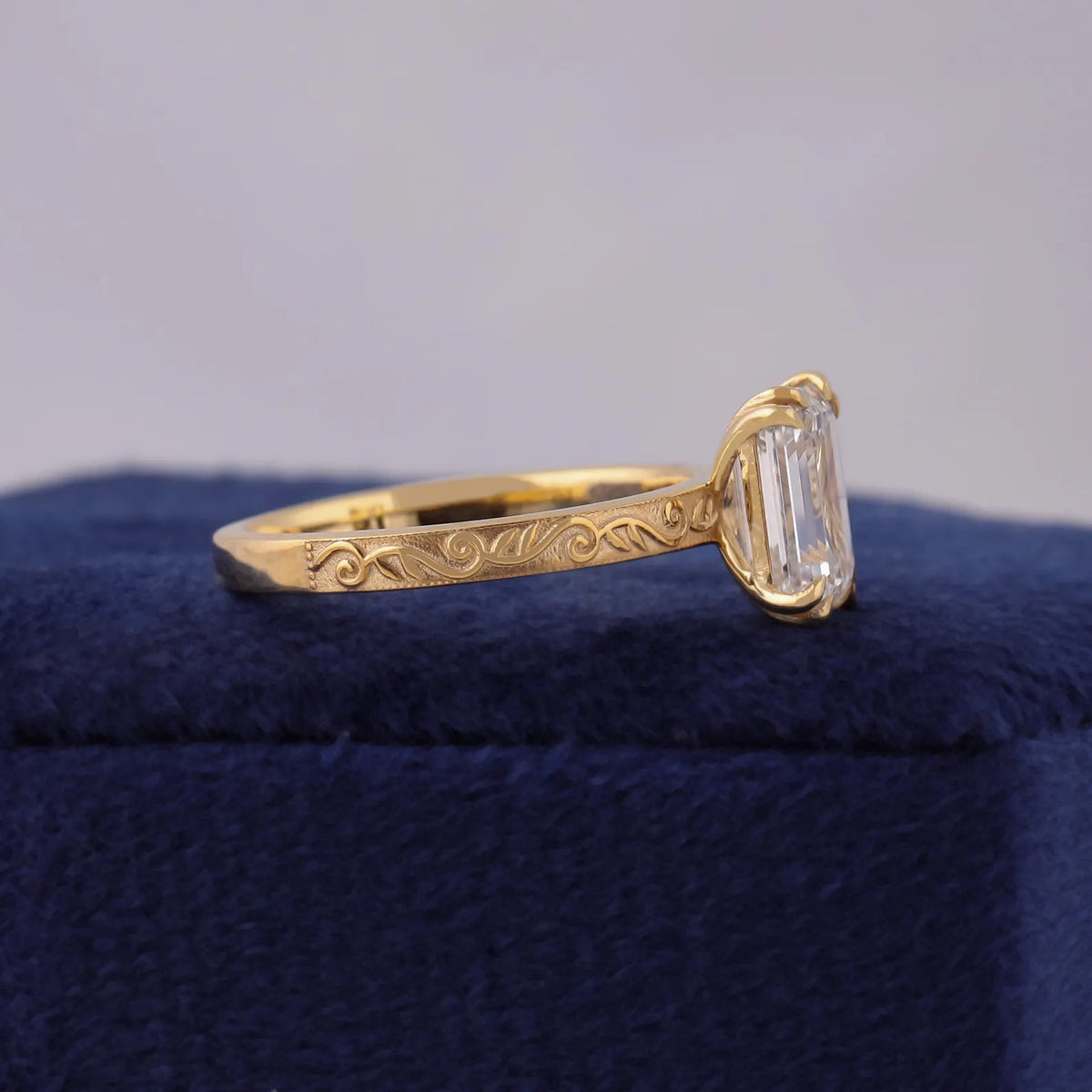 Close-up side view of 14K yellow gold ring band featuring detailed floral scrollwork engraving.
