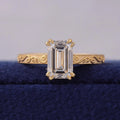 Top front view of 3 CT emerald cut lab grown diamond set on a hand-engraved yellow gold band.