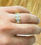 Top-down close-up view of the round cut lab-grown diamond band worn on a hand under warm lighting.