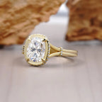 Close-up side perspective of a cushion cut diamond ring showcasing gold bezel halo with micro pave accent stones.