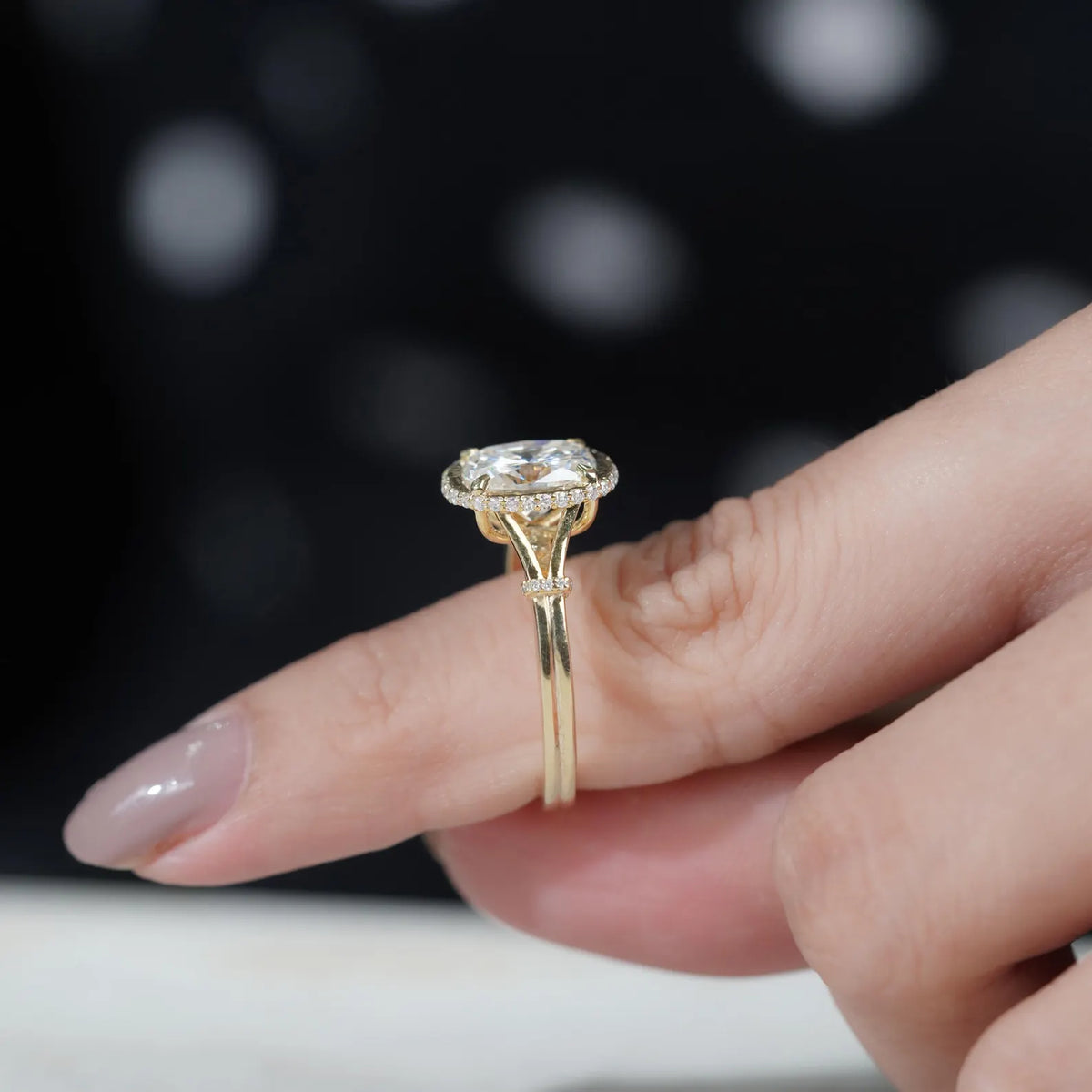 Side profile view on finger showing the height and split shank detailing of a 2 CT cushion cut lab diamond ring.