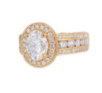 Side angle view of 2 CT oval lab grown diamond ring featuring a halo setting and triple row pave band in yellow gold.