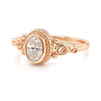 Front view of a 2 CT oval cut pink lab grown diamond ring in a rose gold vintage filigree bezel setting.