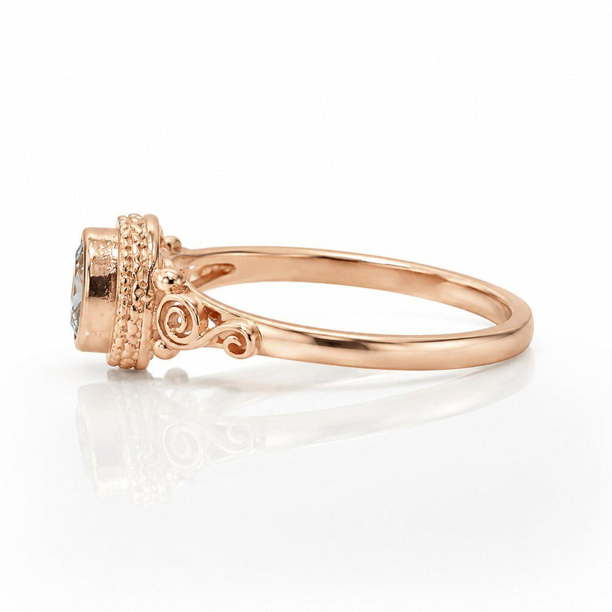 Side profile of rose gold engagement ring band showing detailed scrollwork shoulders and bezel head.