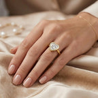 Model wearing a modern 3 carat heart shaped lab diamond ring with a yellow gold bezel frame.