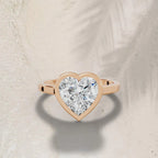 3ct heart cut lab grown diamond ring with a rose gold bezel setting on a neutral background