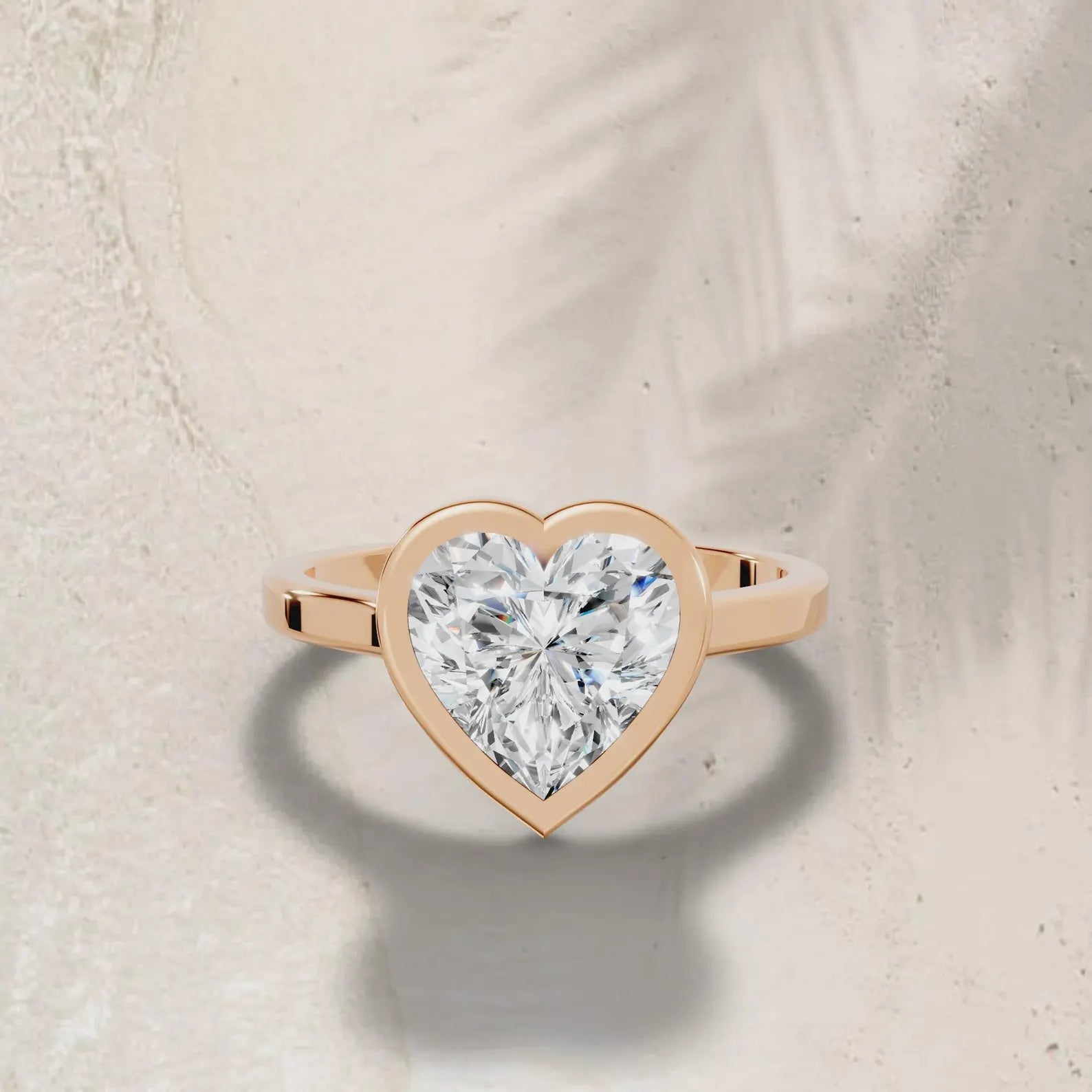 3ct heart cut lab grown diamond ring with a rose gold bezel setting on a neutral background