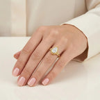 On-hand photo of 3 CT pear cut lab diamond engagement ring in yellow gold with leaf design.