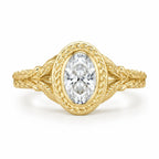 Direct top-down view of a 3 carat oval lab created diamond framed in a laurel leaf engraved yellow gold bezel.