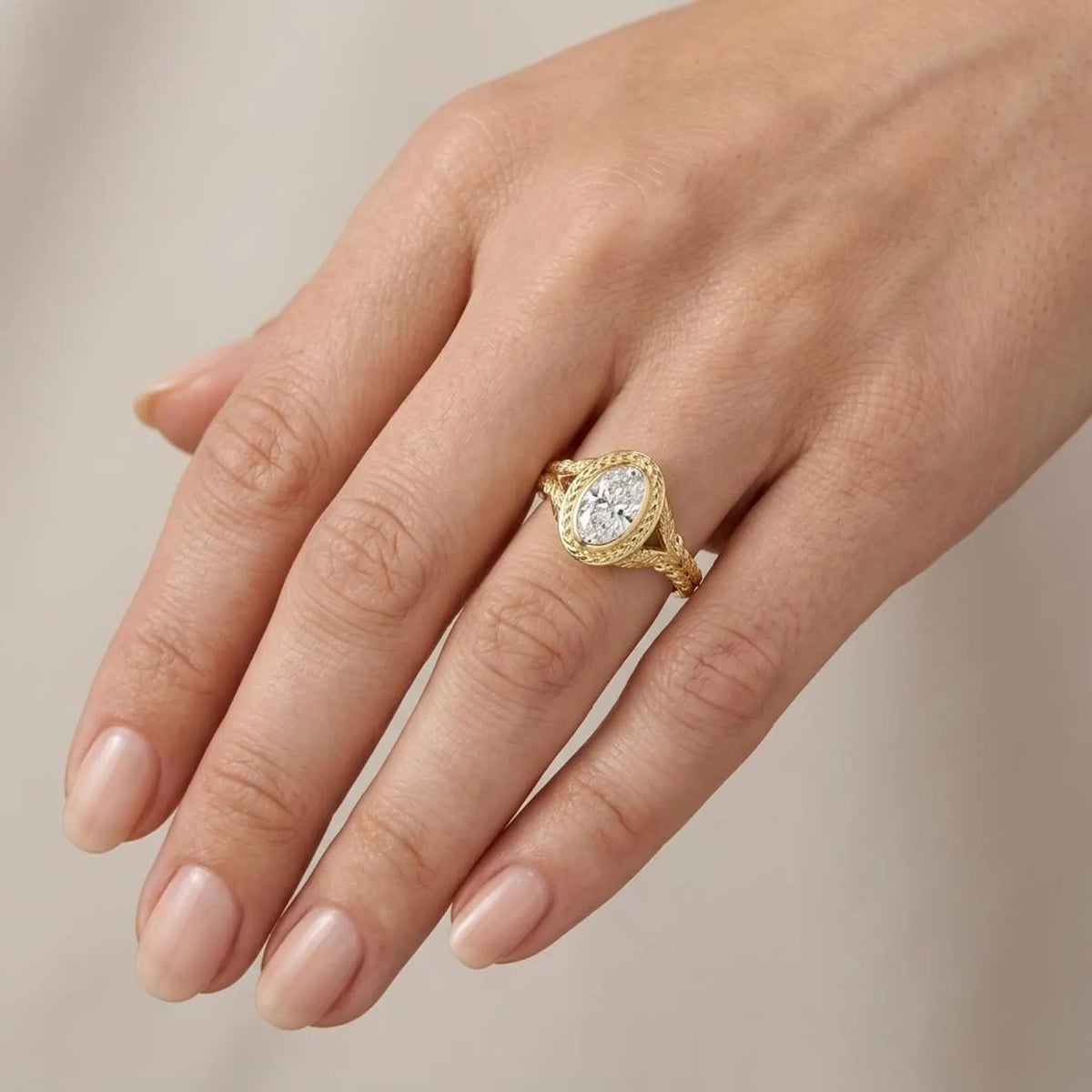 On-hand wearing perspective of a vintage 3 CT oval lab-grown diamond ring in yellow gold with leaf details.
