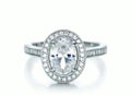 Frontal top-down view of a 3 CT oval cut lab grown diamond engagement ring with a milgrain-bordered halo and pavé band.