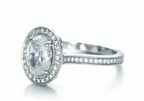 Three-quarter angle of 3 carat oval lab diamond ring showing milgrain edges along the pavé shank.