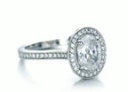 Side angle highlighting the brilliant faceting of the oval lab diamond center stone and surrounding halo.