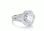 Angled view of a 2 CT round lab grown diamond engagement ring with a floral swirl halo and milgrain pavé band.