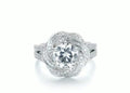 Top-down view of a 2 carat round lab diamond center stone enclosed in a micro-pavé swirl halo setting.