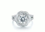 Top-down view of a 2 carat round lab diamond center stone enclosed in a micro-pavé swirl halo setting.