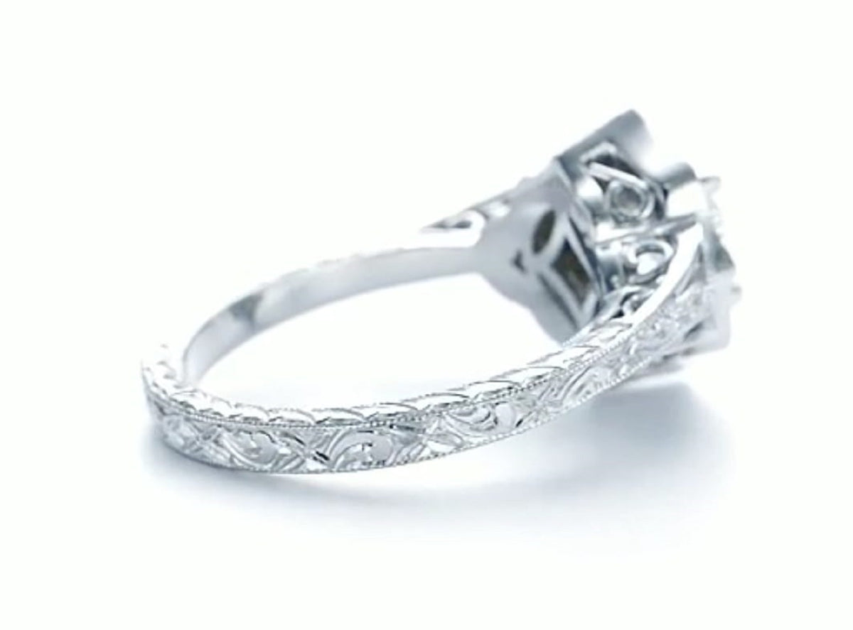 Close-up of intricate hand-carved floral scrollwork and milgrain detailing on the ring band.
