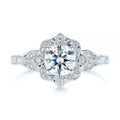 Clean studio top-down view of a 3 CT round brilliant lab diamond in a floral halo setting with leaf shoulders.