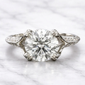 Top-down direct view of a 3 carat round cut lab grown diamond ring with micro-pavé side accent diamonds set in white gold.