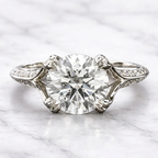 Top-down direct view of a 3 carat round cut lab grown diamond ring with micro-pavé side accent diamonds set in white gold.