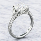 Three-quarter angle showing a 3 CT round brilliant lab grown diamond ring featuring a cathedral setting and pavé diamond band.