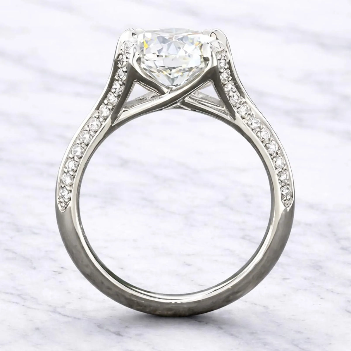 Direct side profile view illustrating the architectural cathedral arch and under-gallery basket of a 3 carat round lab grown diamond engagement ring.